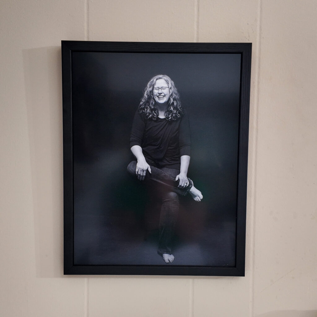 11x14 inch framed metal print of Jennifer hanging on the wall