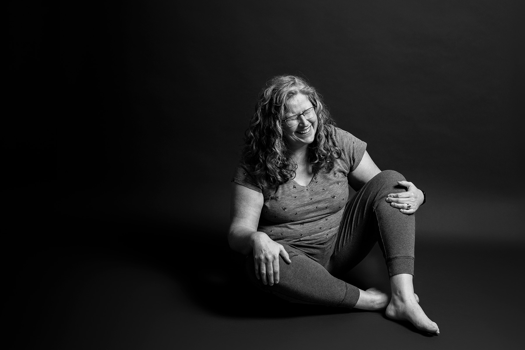 Jennifer laughs about a story from her motherhood journey in a self-portrait from her Postpartum Project session.